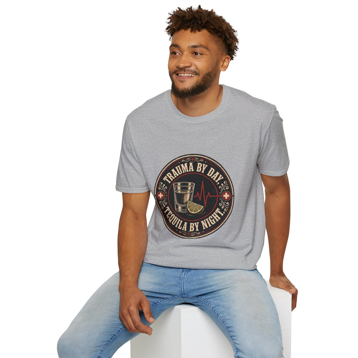 Trauma by Day, Tequila by Night Shirt, Sport Grey, worn by a model seated on a white block