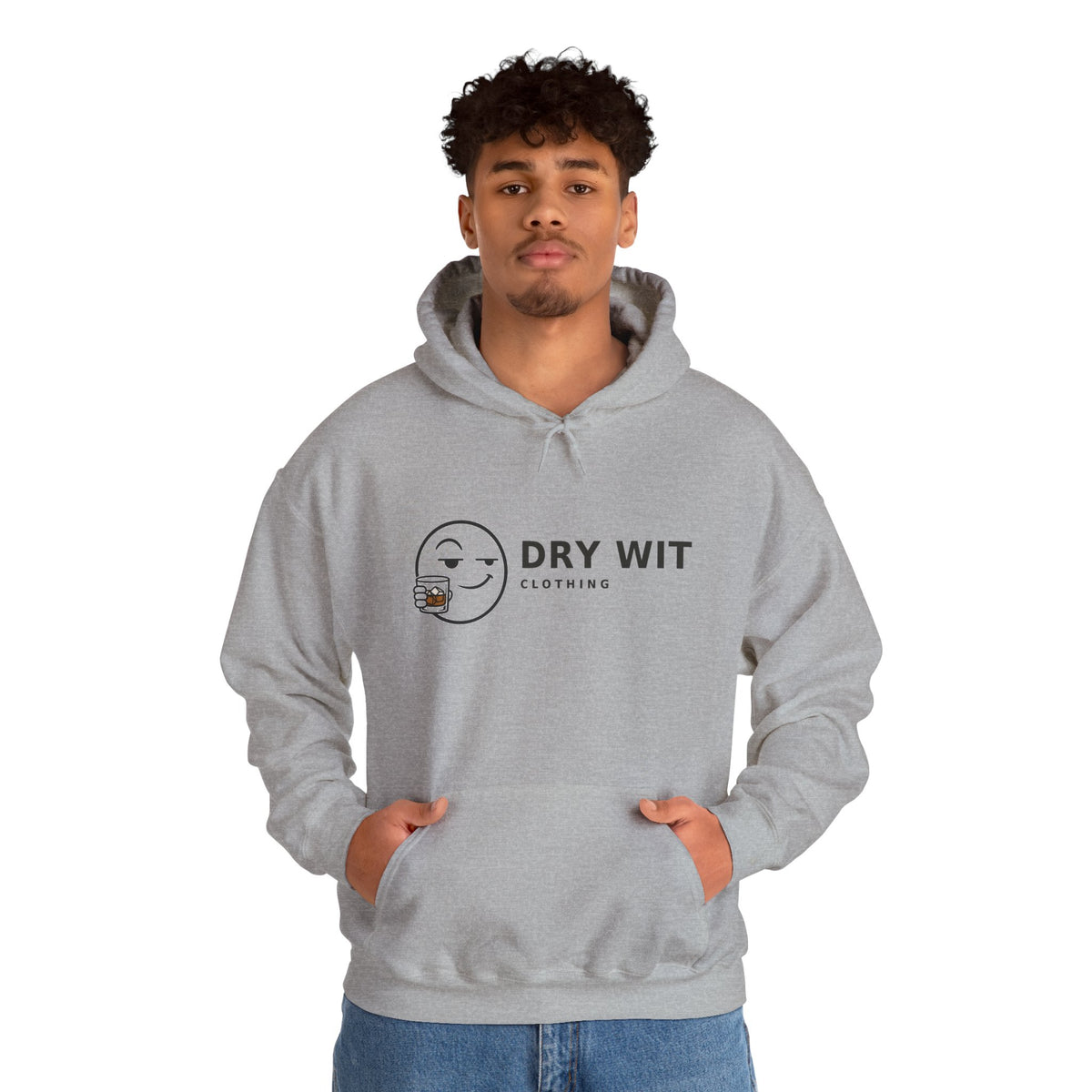 Dry Wit Clothing logo hoodie with winking emoji holding a whiskey glass, Sport Grey, worn by a standing model with blue jeans, hands in the front pouch pocket