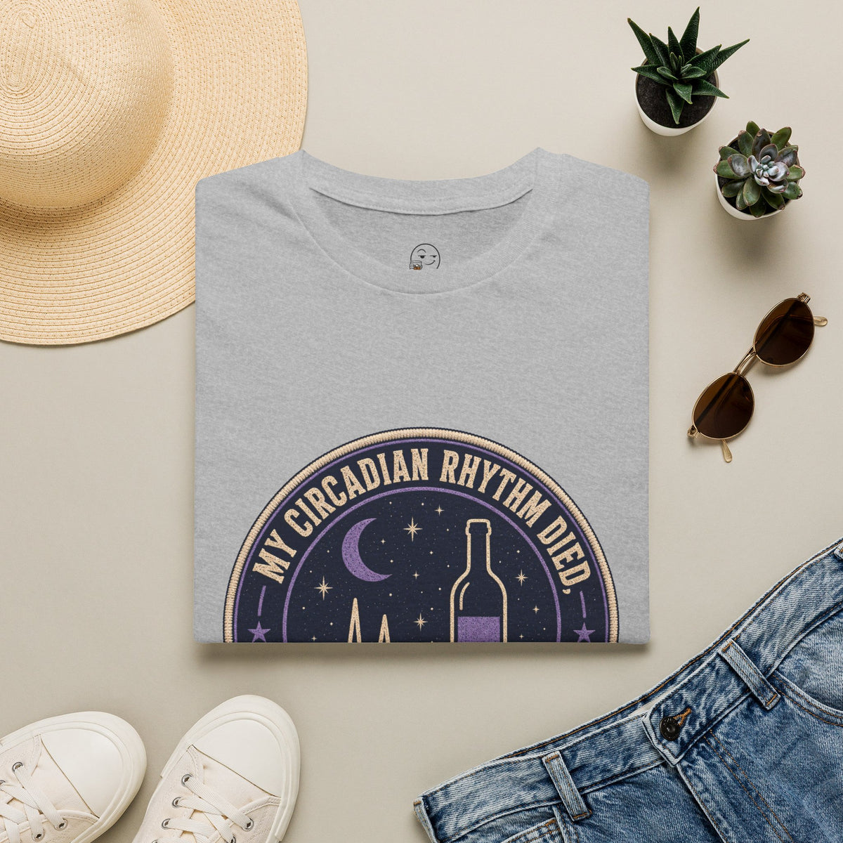 My Circadian Rhythm Died Shirt, Sport Grey, folded flat lay styled with a straw hat, sunglasses, sneakers and denim