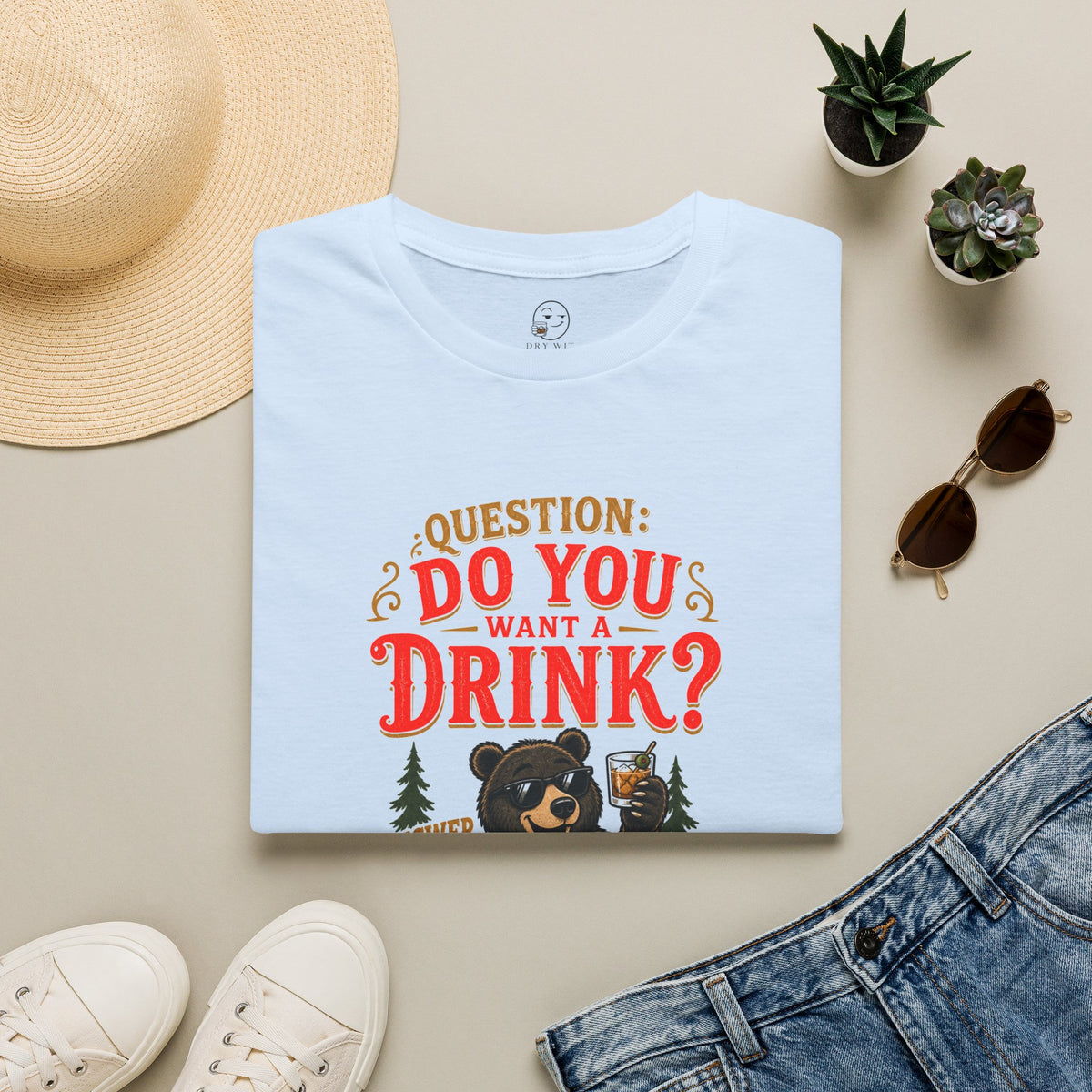 Does a Bear... Want a Drink? Shirt, Light Blue, folded flat lay styled with a straw hat, sunglasses, sneakers and denim