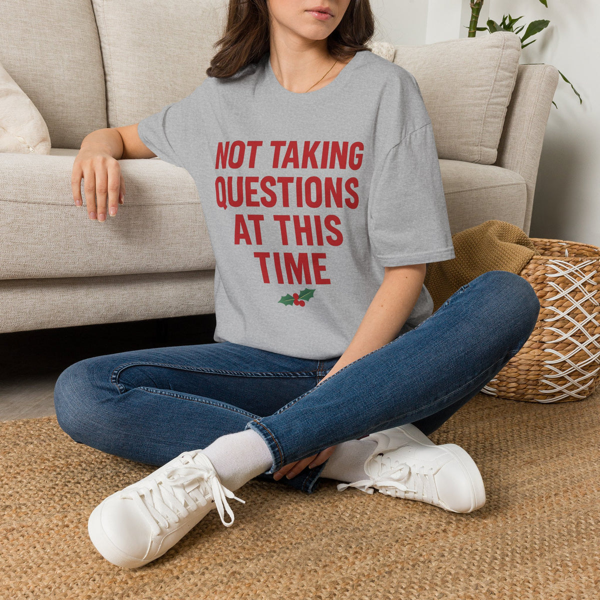Not Taking Questions at This Time Shirt, Sport Grey, worn by a model seated on the floor beside a sofa