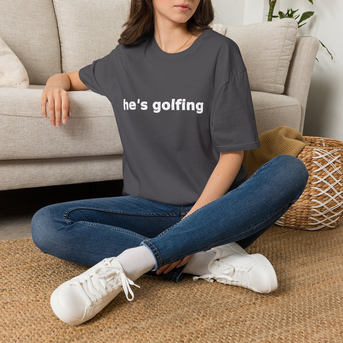 Golf Widow Shirt, Charcoal grey, worn by a model seated on the floor beside a sofa
