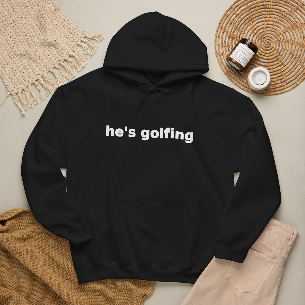 Golf Widow he's golfing funny golf hoodie, Black, flat lay styled with a knit throw, candle and tan trousers