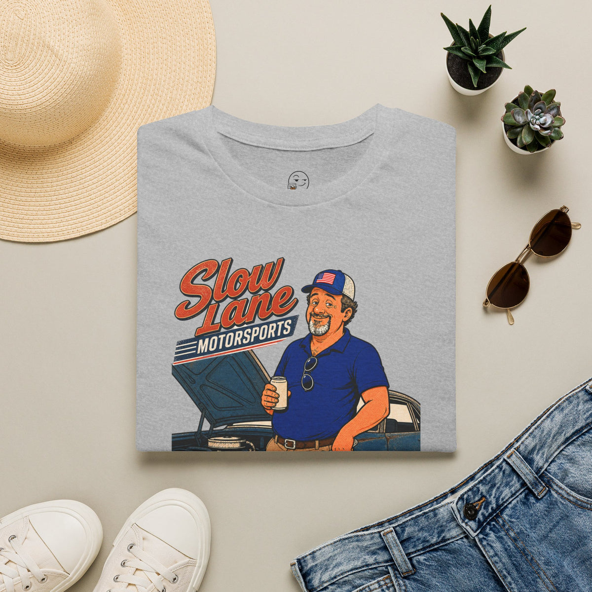 Slow Lane Motorsports Shirt, Sport Grey, folded flat lay styled with a straw hat, sunglasses, sneakers and denim