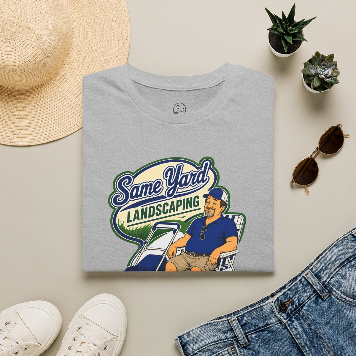 Same Yard Landscaping Shirt, Sport Grey, folded flat lay styled with a straw hat, sunglasses, sneakers and denim