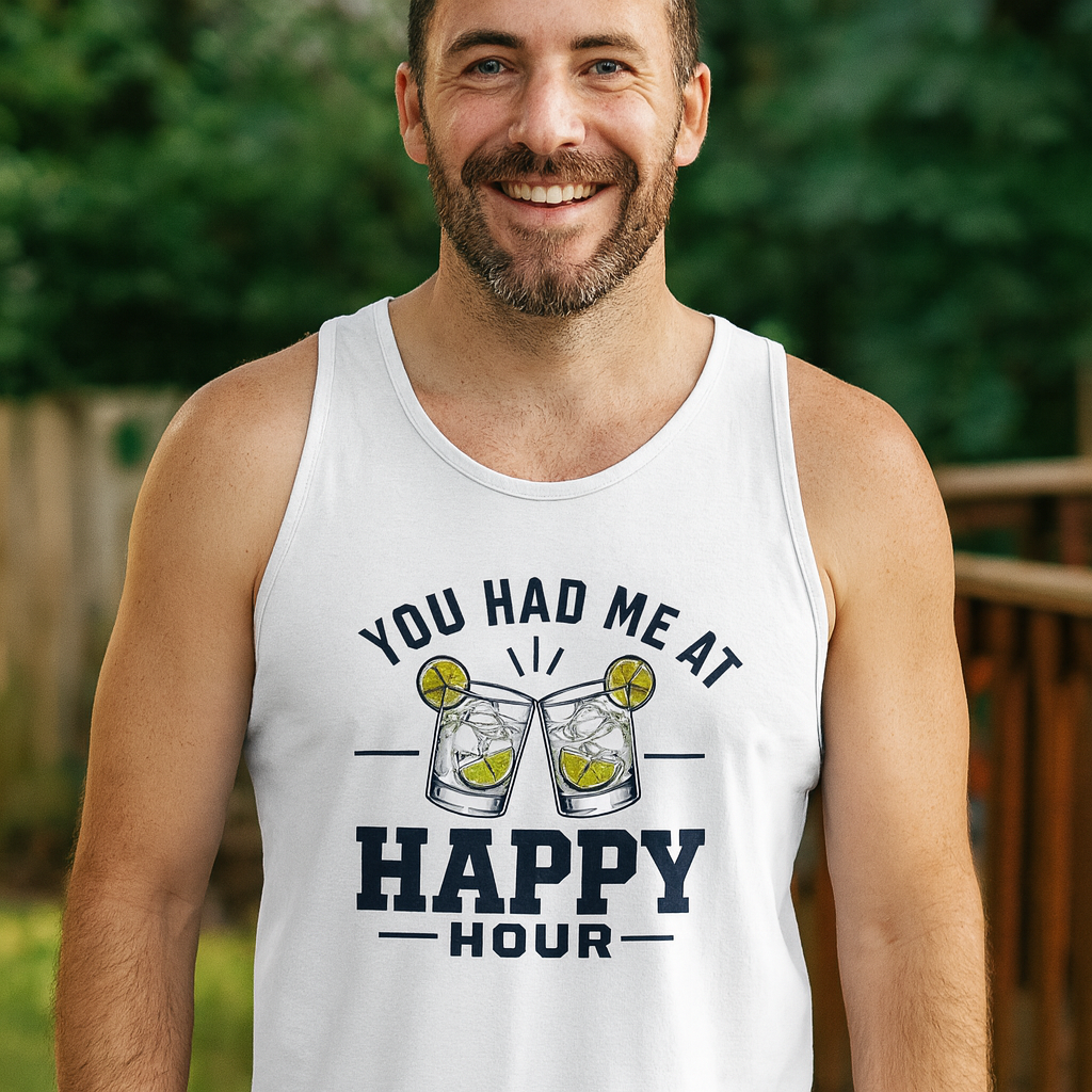 Smiling man in a white You Had Me At Happy Hour tank top standing outdoors